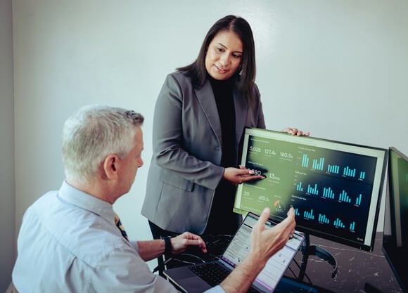 A woman pointing to a screen of analytics