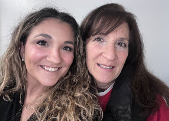 Two women smile for a selfie.