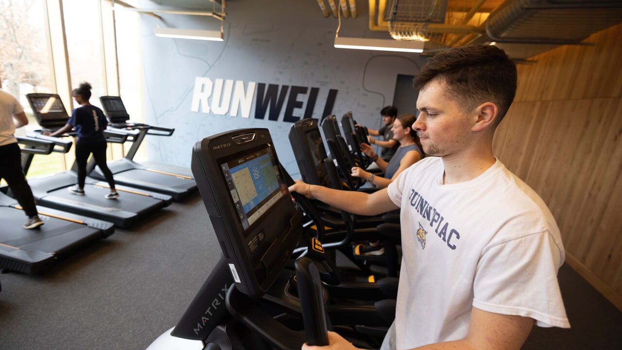 A student adjusts the screen on his treadmill in the Recreation and Wellness Center