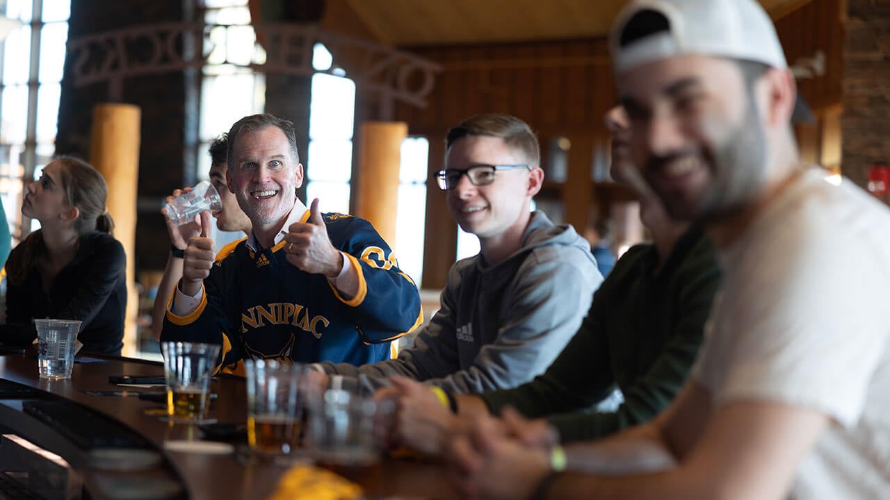 Students cheer on men's ice hockey at On the Rocks Pub and Grill