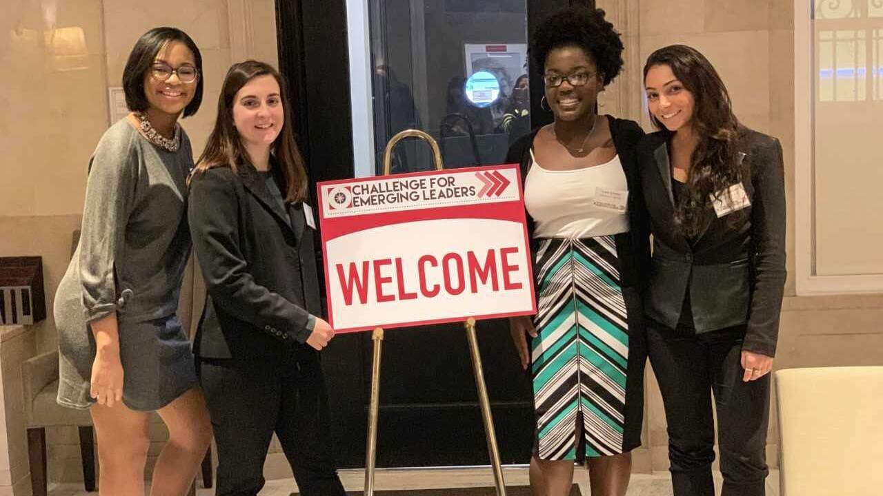 Chelsea Jones, Catherine Fabiano, Luna Charles and Deanna DiRienzo pose for a photo together with a sign for the Challenge for Emerging Leader workshop