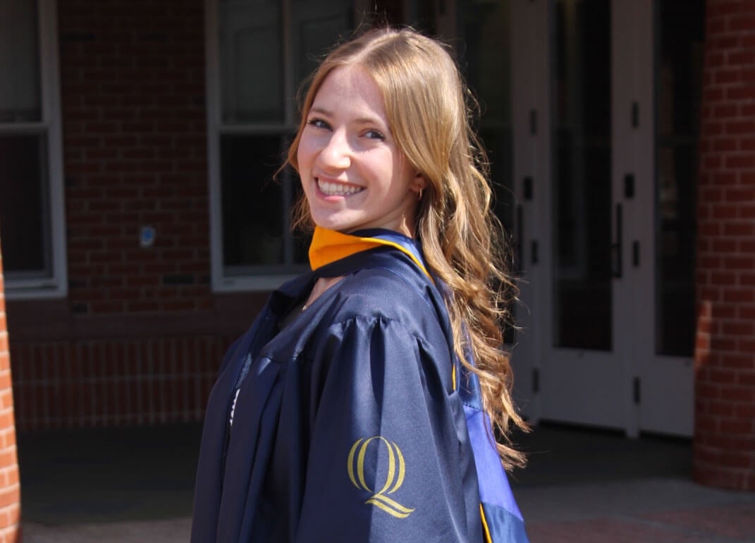 Justine Lewicki smiling in her graduation gown