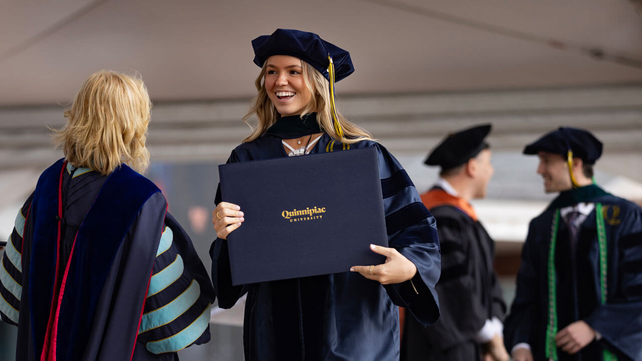 After being awarded with a diploma, a Health Sciences graduate student grins proudly.