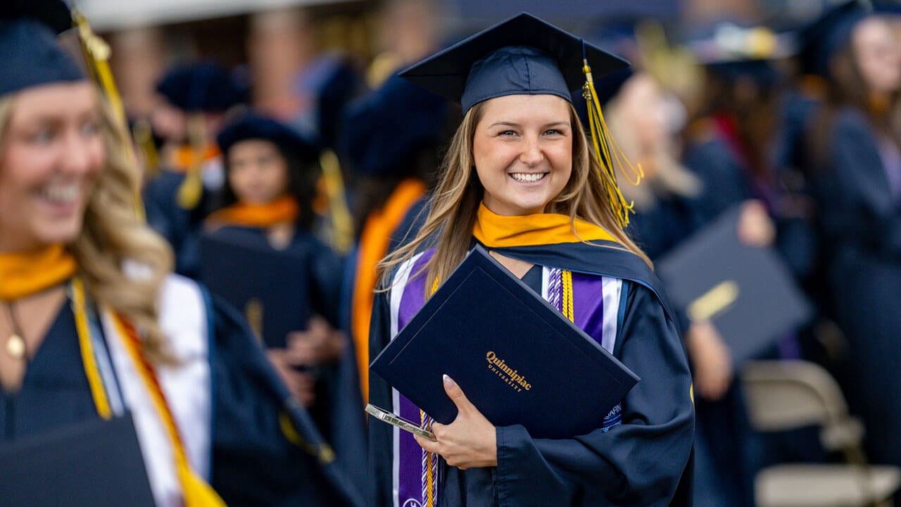 graduate smiles with diploma