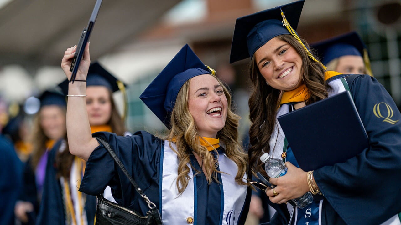graduates celebrate with their diplomas
