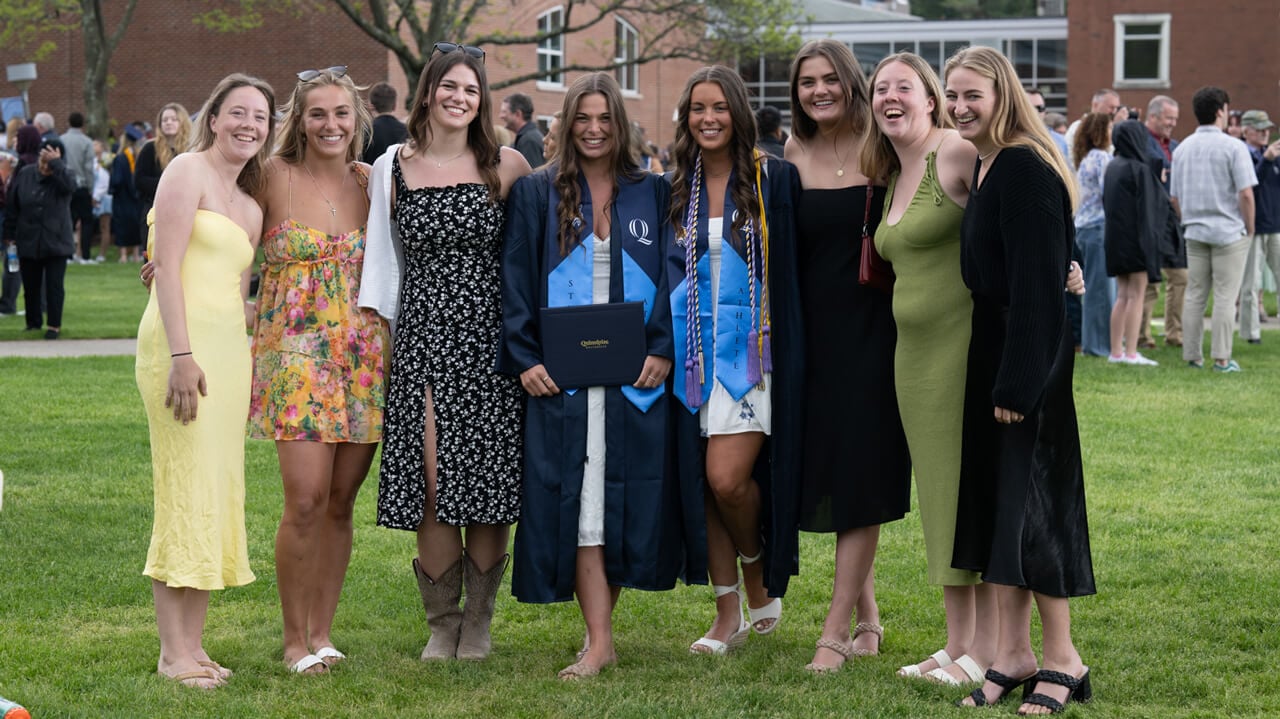 Two graduates pose for a photo with guests