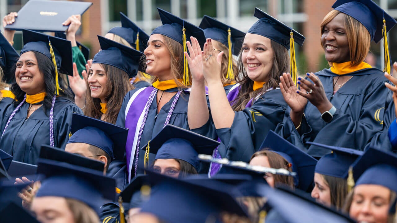 Quinnipiac soED graduates stand to clap after ceremony