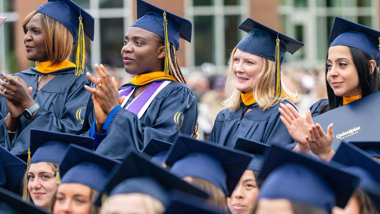 Quinnipiac graduates clap after recieving their degrees