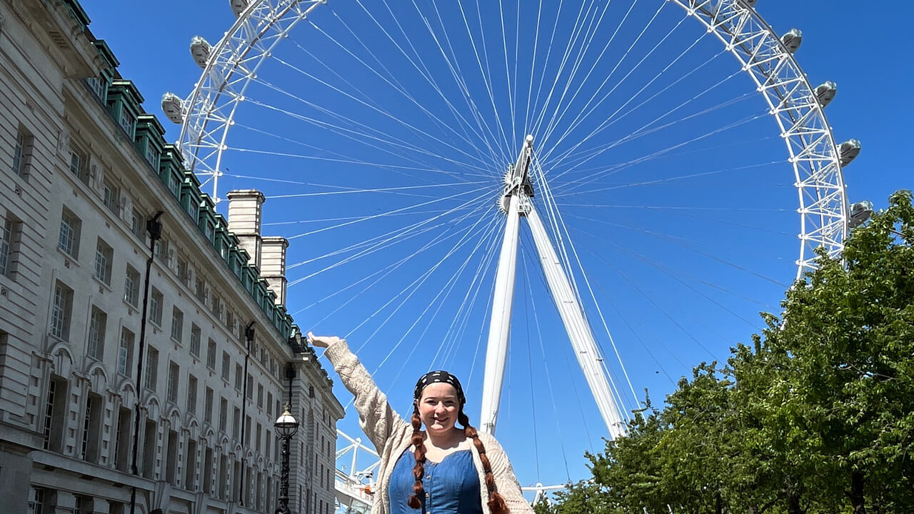 a female student posing in front of the London Eye
