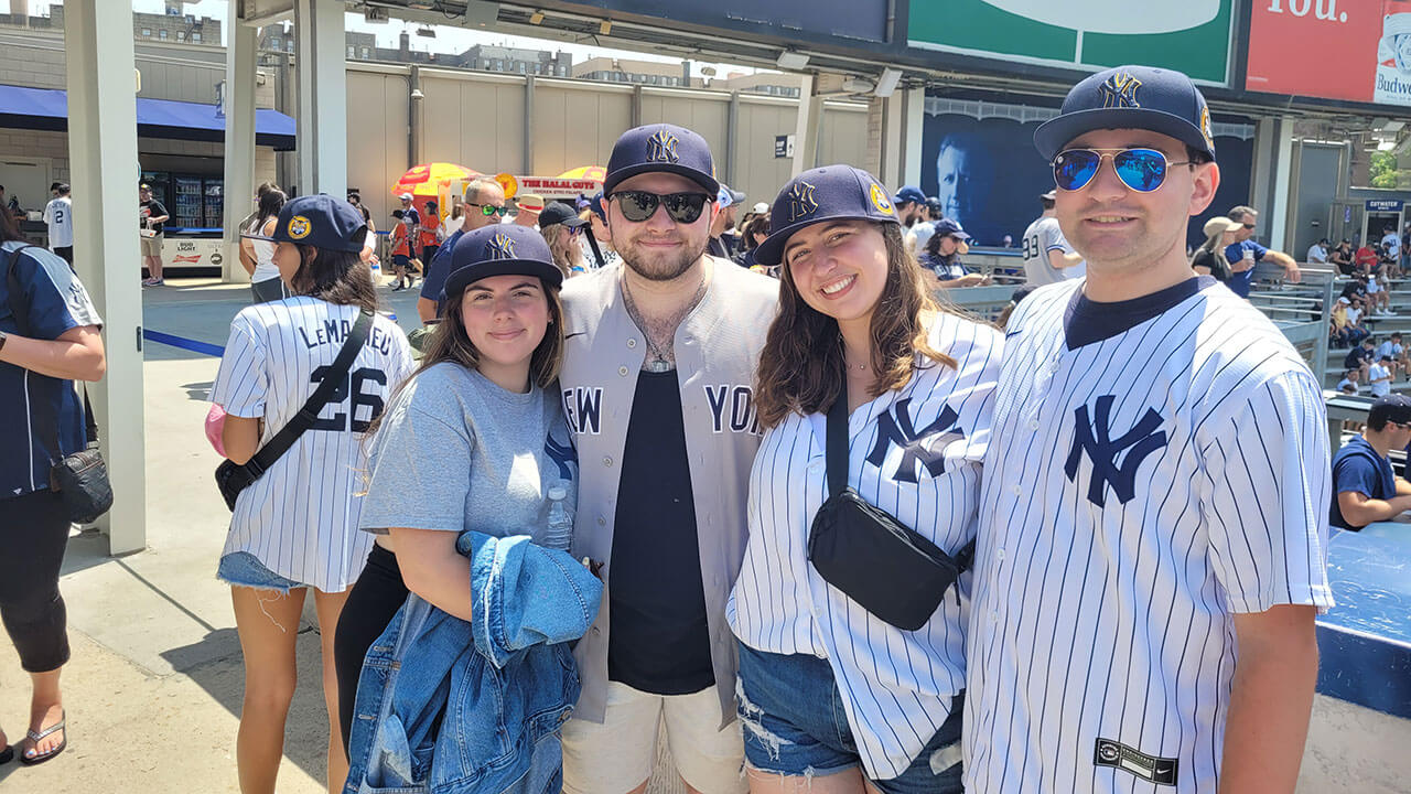 A group of alumni smile for a photo at a Yankee game