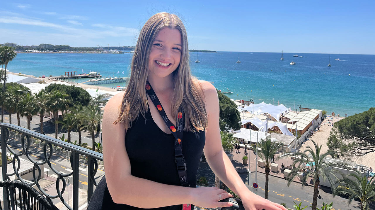 Isabella Foley takes a photo in front of the water in Cannes, France