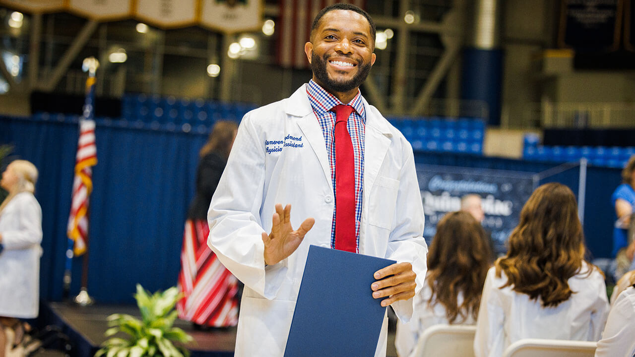 Graduate accepts his white coat on stage