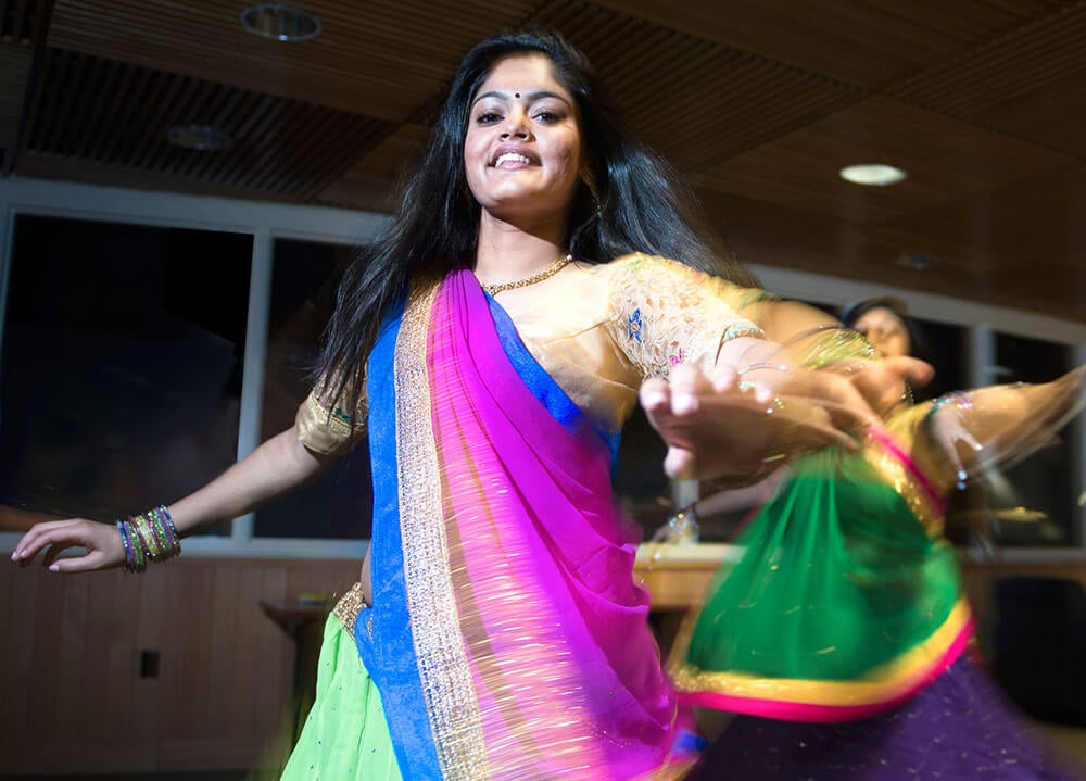 A student performs a Bollywood dance wearing a colorful gown