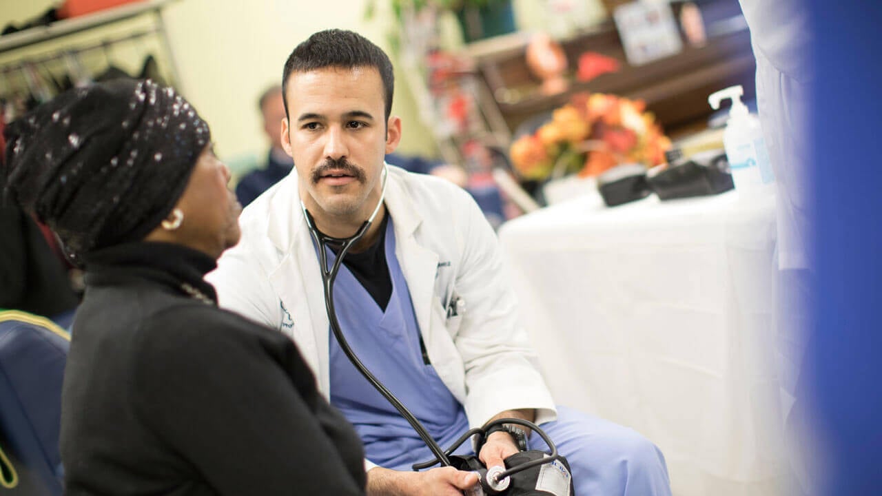 Student speaks with patient during a health fair