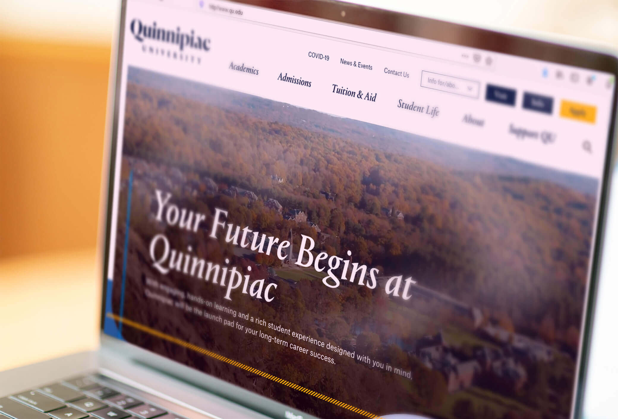 Laptop screen showing the landing page of Quinnipiac's website..