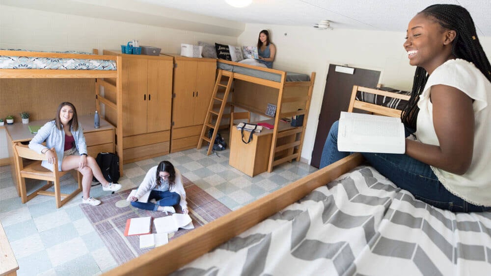 Four students talk in their residence hall room