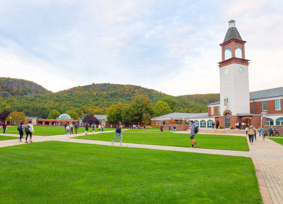 Students walk across the quad with the Sleeping Giant in the background on a beautiful fall day.