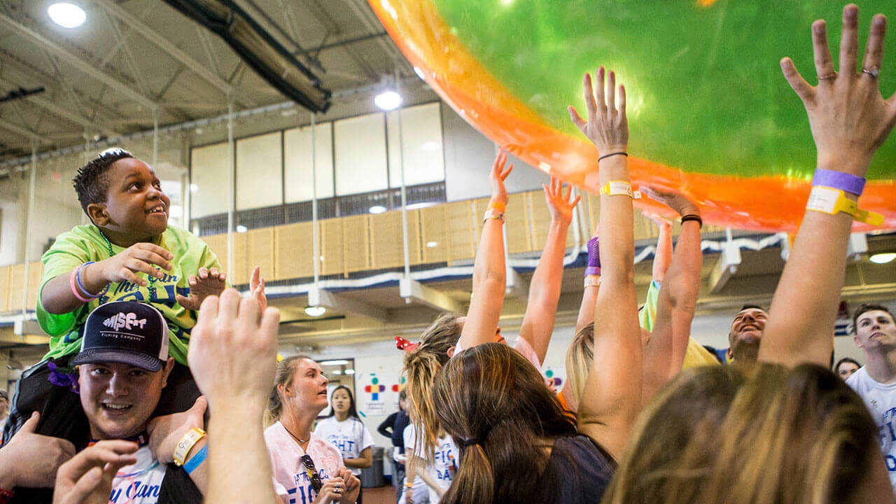 Students hold up giant, colorful beachball