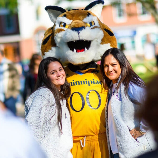 A student and her mother smile next to the Boomer mascot