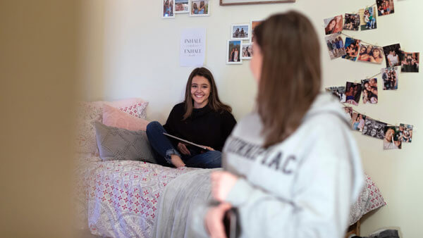 Two students sit and talk in their dorm room