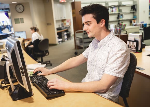A person works at a computer in an office setting