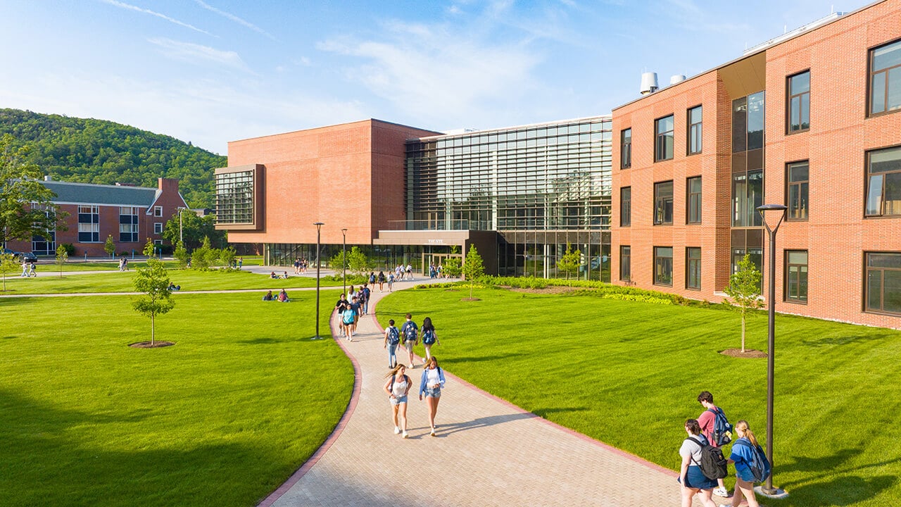 Wide view of the South Quad with students walking between buildings on the brick walking paths