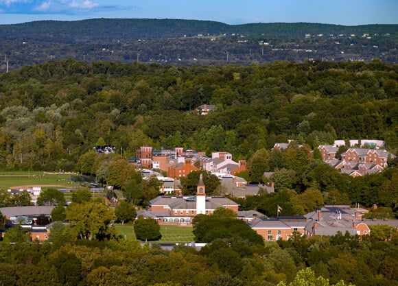 Aerial view of the Mount Carmel Campus on a sunny day with green trees surrounding red brick buildings