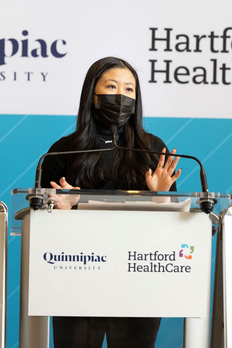 Nursing student Gillian Chung speaks at a podium during a press conference