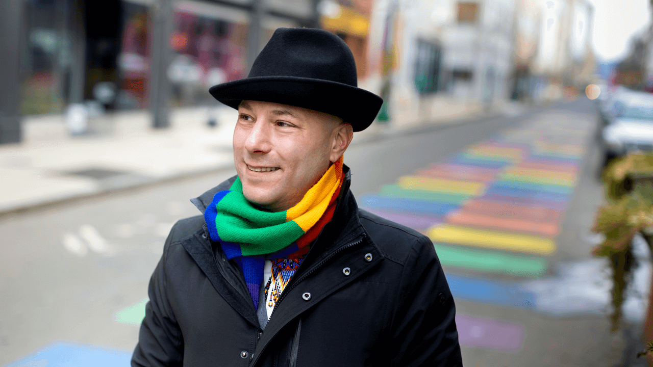 Vince Contrucci walks across a street with a rainbow crosswalk in New Haven