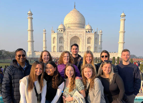 MBA students stand in front of the Taj Mahal in India.