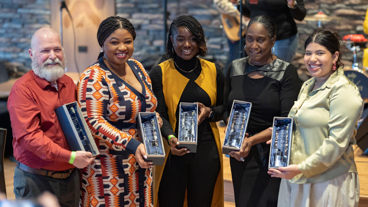 Award recipients smile together and hold up their Quinnipiac MLK Dream awards