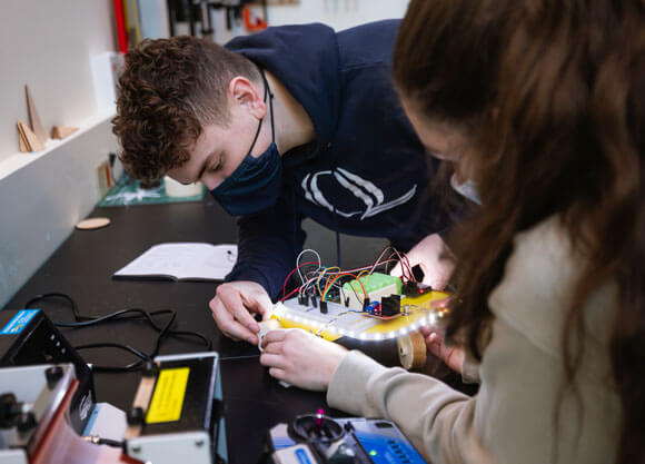 Students at work work on their mechatronic creation in an engineering lab