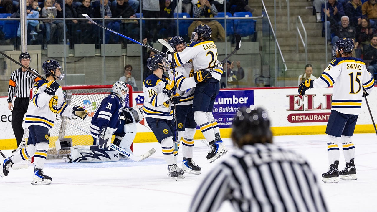 Quinnipiac men's ice hockey players score a goal against Yale.