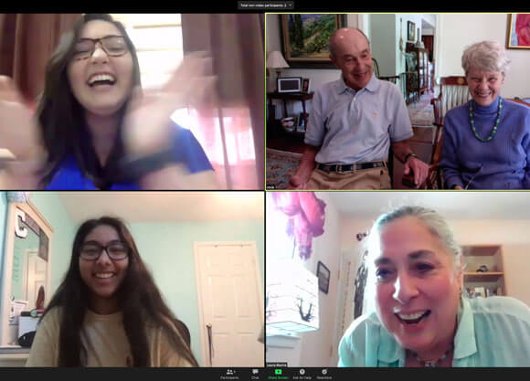 Students and professor laughing on zoom while collaborating on legacy book for people with dementia