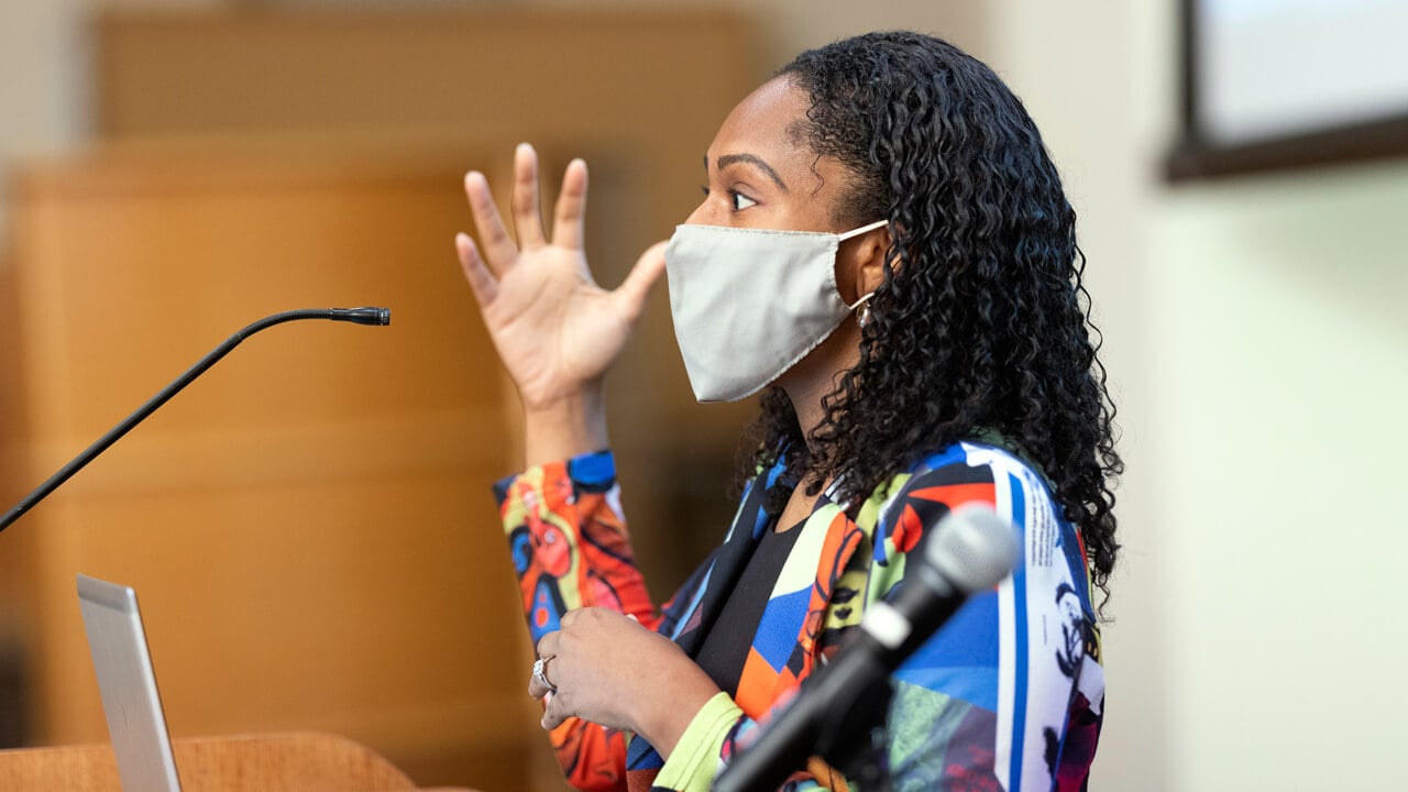 Adriane Jefferson speaks with a mask at a podium during a Black History Month event at Quinnipiac