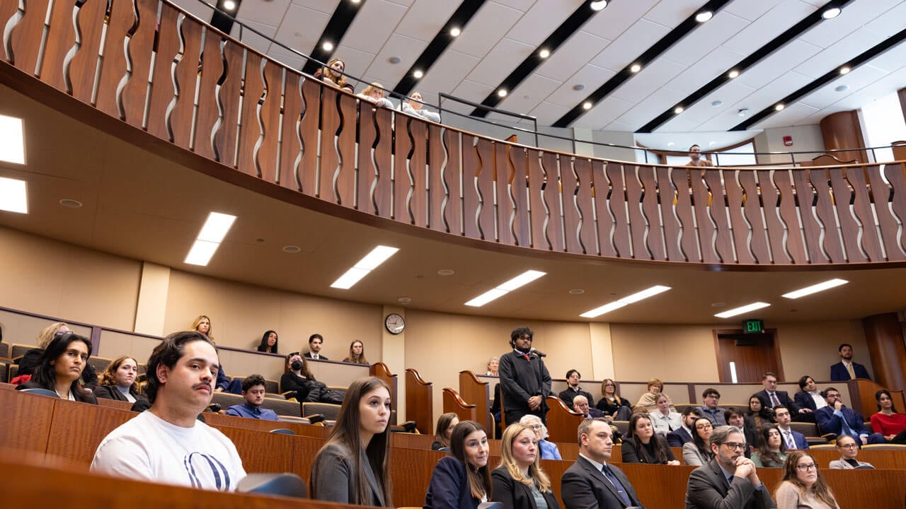 Students and audience members occupy a courtroom, all facing the front