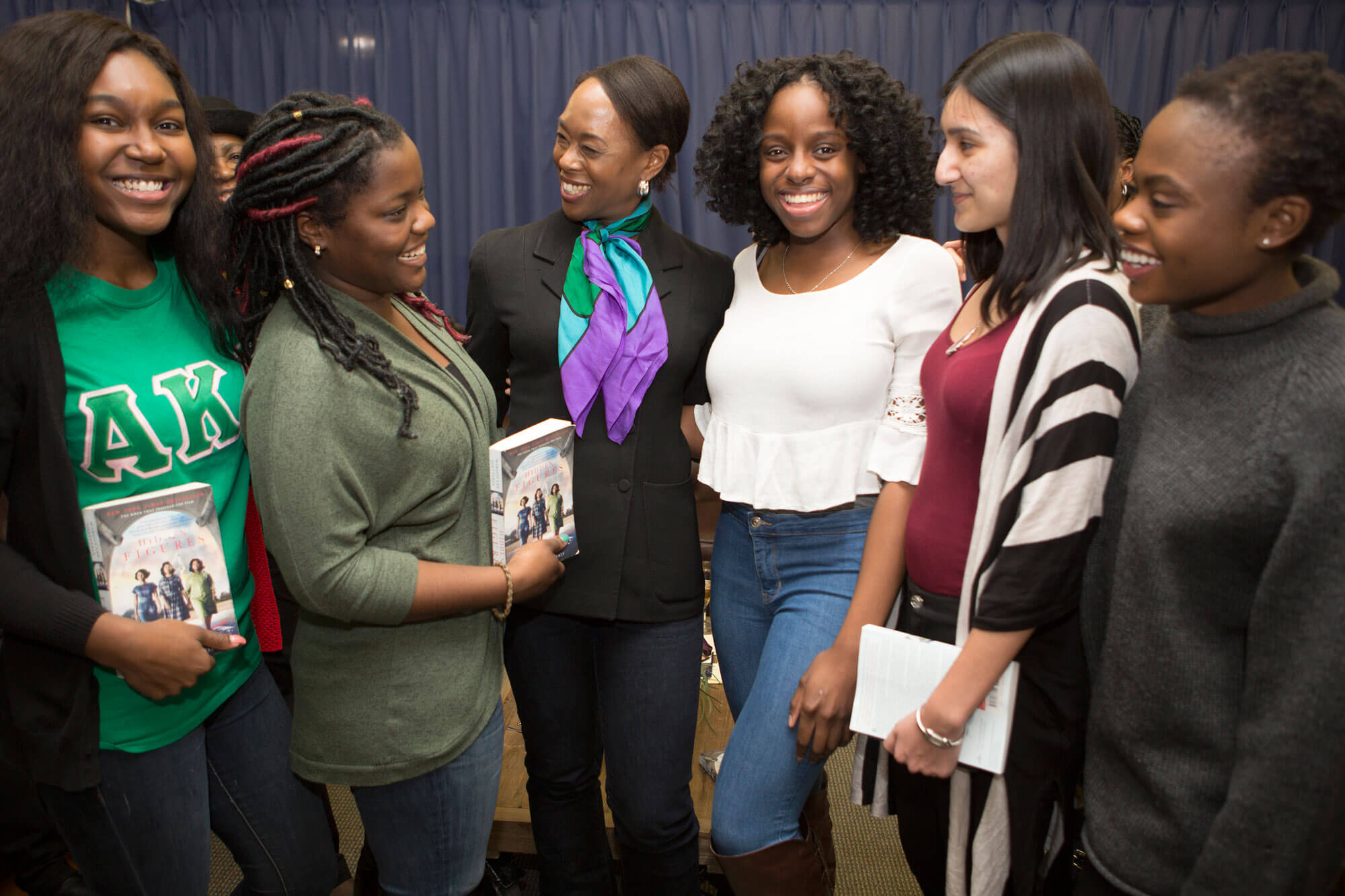 Margot Lee Shetterly smiles for a photo with several Quinnipiac students.