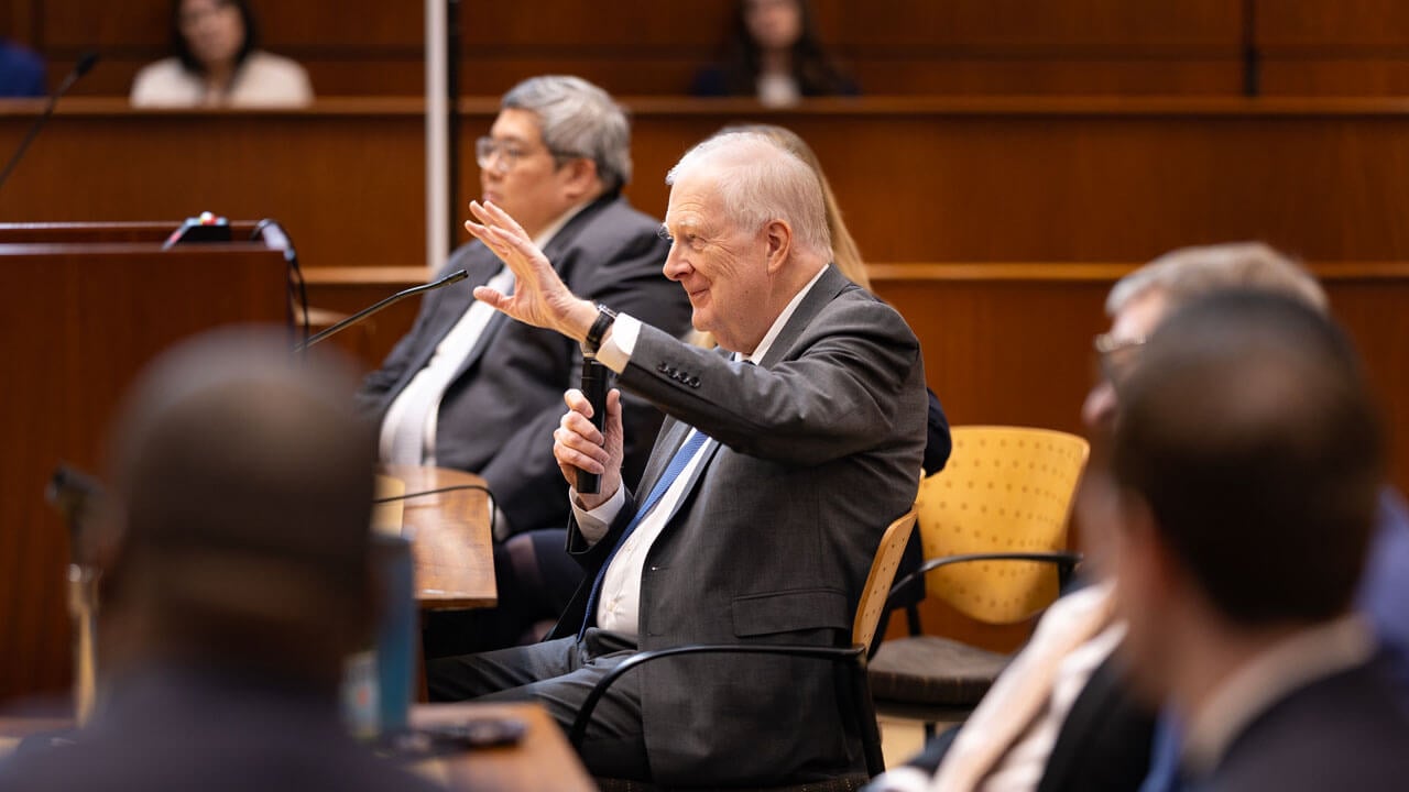 Individuals talking towards the crowd in the courtroom