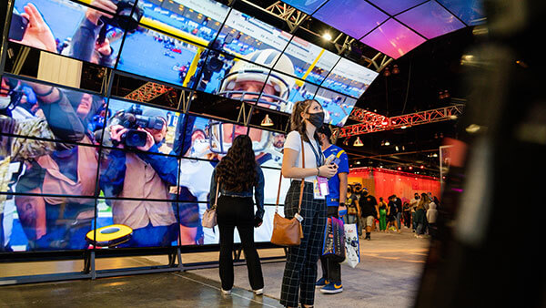 Quinnipiac student watches video play on screens at the NFL Experience at Super Bowl 56 in Los Angeles, California.