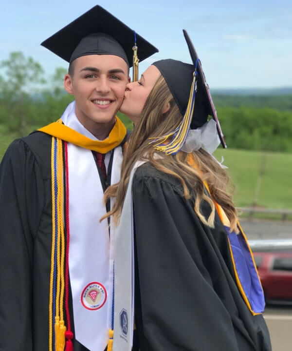 Britni kisses Branden on the cheek at their graduation.