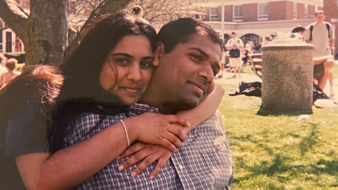 Milind and Anjali Shah hugging each other as young students on the quad.