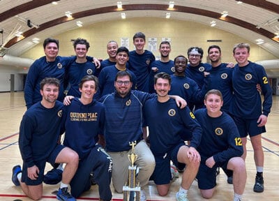 Group of men posing with trophy club volleyball