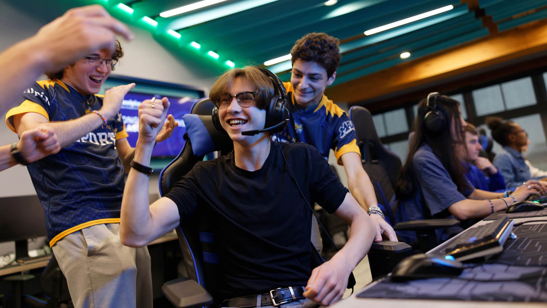 Quinnipiac students celebrate after winning a game in the eSports lab.