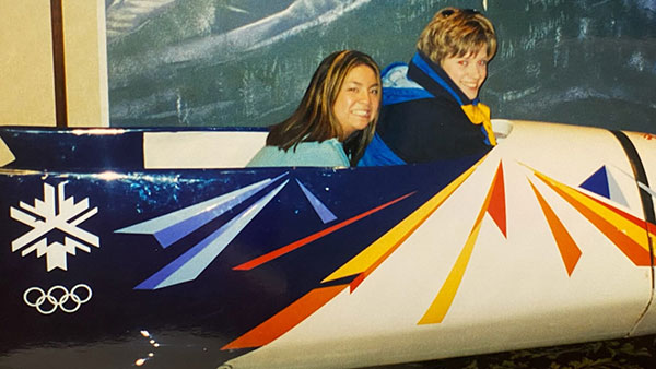 Professor Andrea Luoma sits in a bobsled with another person at the 2002 winter Olympics in Salt Lake City, Utah.