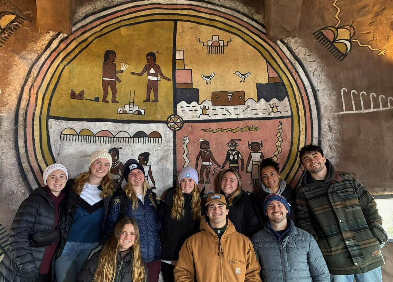 Quinnipiac nursing students pose in front of artwork