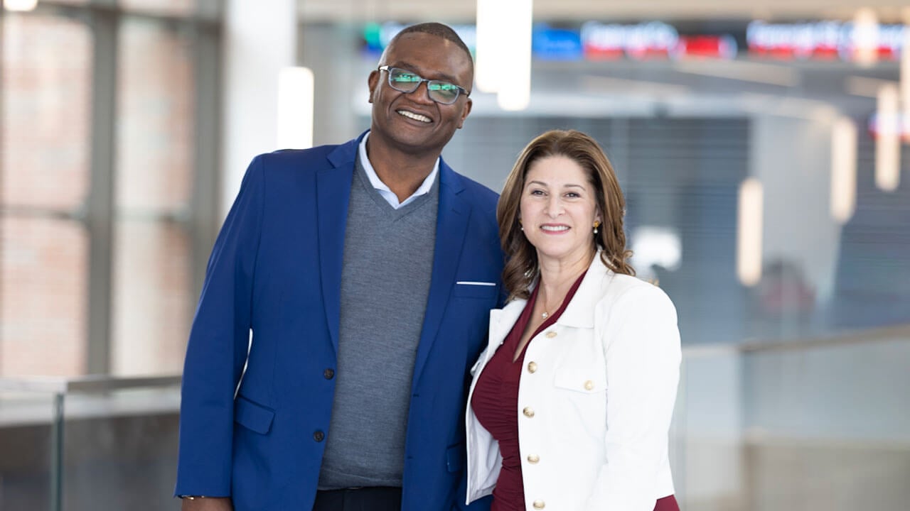 School of Business dean Holly Raider smiles next to Yale School of Management Dean Kerwin Charles