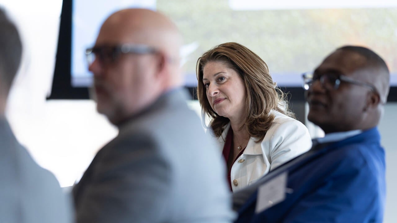 Dean Holly Raider looks at a speaker in the meeting