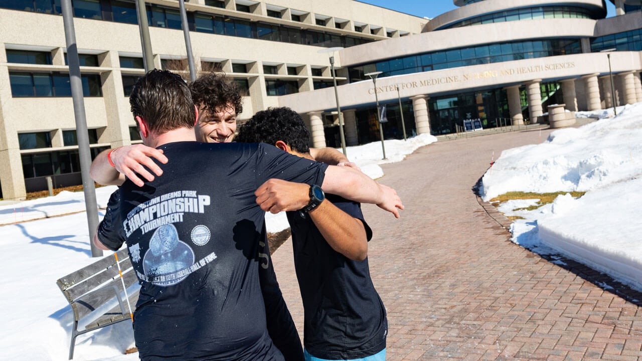 Students hug and celebrate after plunging in the dunk tank