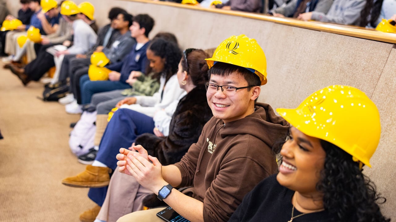 Students smile about receiving hard hats