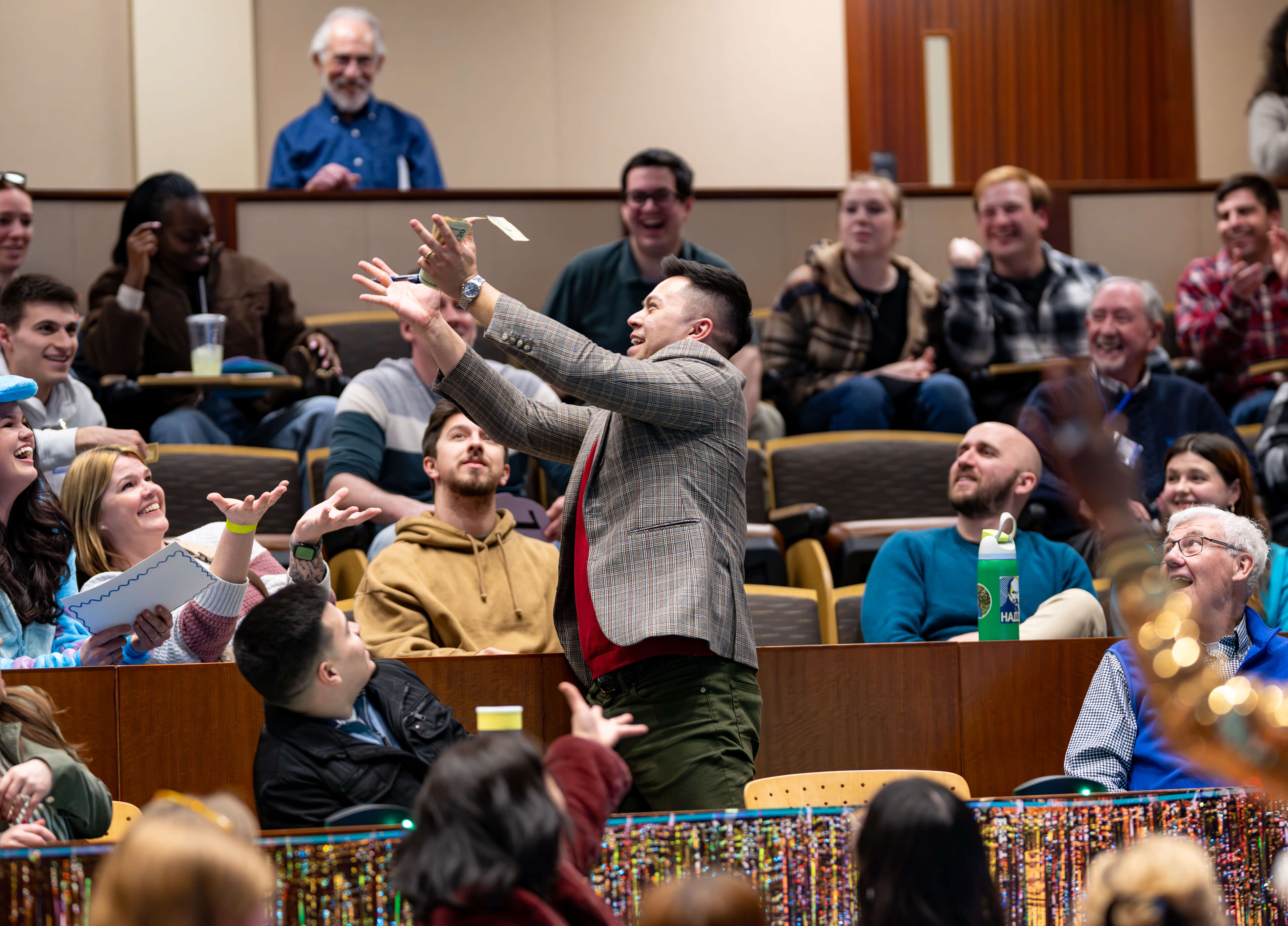 Individual holds up money and smiles at the 33rd Annual PILP Auction
